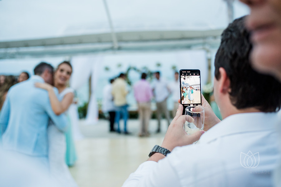 convidado fazendo foto com celular dos noivos dançando