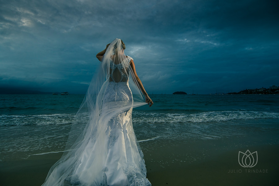 noiva linda de costas, com seu vestido de noiva na praia ao entardecer, na pousada dos sonhos em florianópolis, jurere
